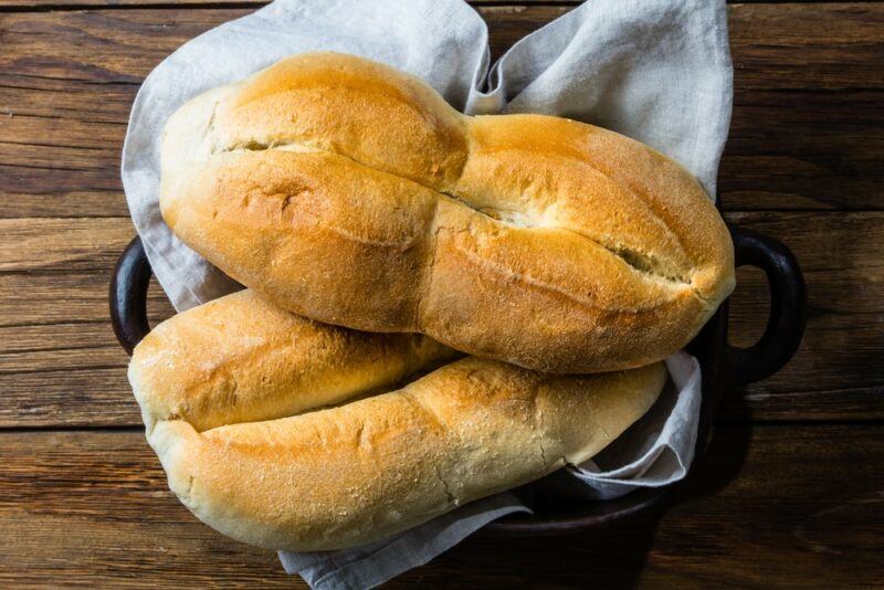 Two pieces of Chilean bread in a container with a white cloth