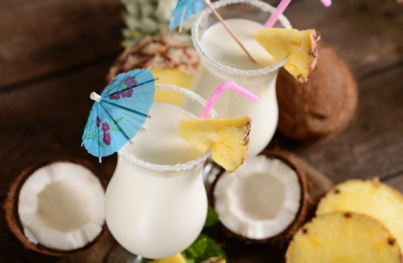 Two large pina coladas next to coconut halves