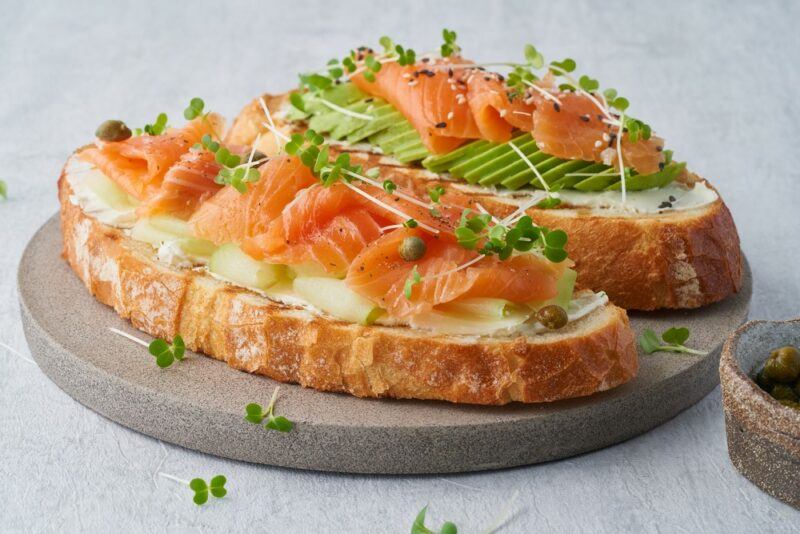 Two open sandwiches with salmon and avocado