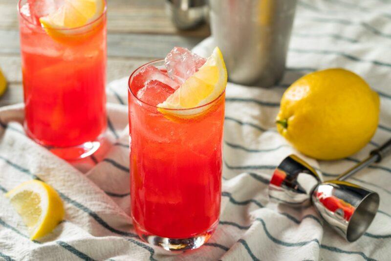 Two sloe gin fizz cocktails on a striped cloth