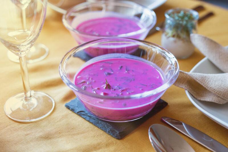 Two glass bowls containing a purple chlodnik soup