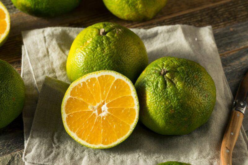 A cloth with two whole ugli fruits and one that's been sliced in half