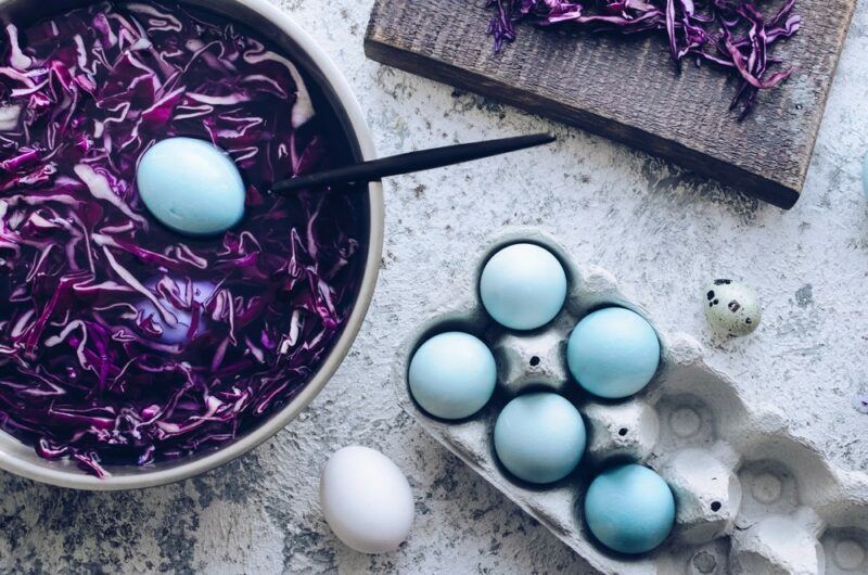 A large bowl of red cabbage that is being used to dye Easter eggs a light blue