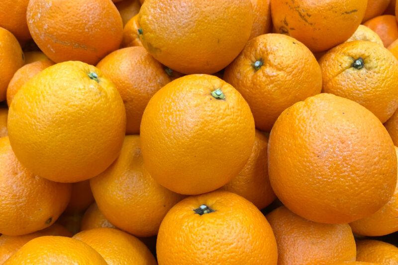 closeup image of a pile of Valencia oranges