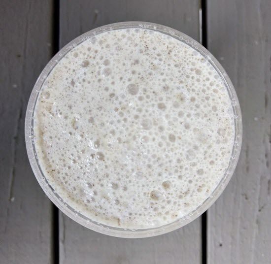 A top down image of a vanilla smoothie  on a wooden table.