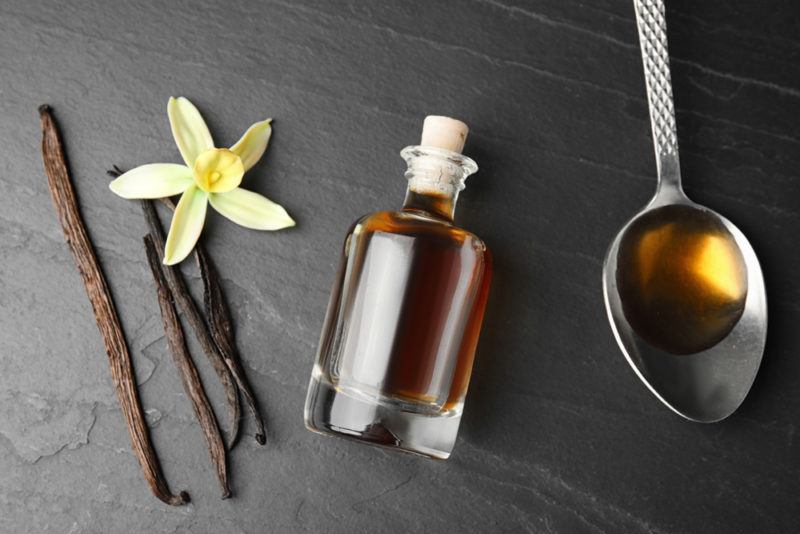 Vanilla pods, a bottle of vanilla extract and vanilla on a spoon