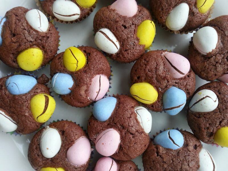 A selection of round brownie bites with yellow, blue, pink, and white Easter eggs