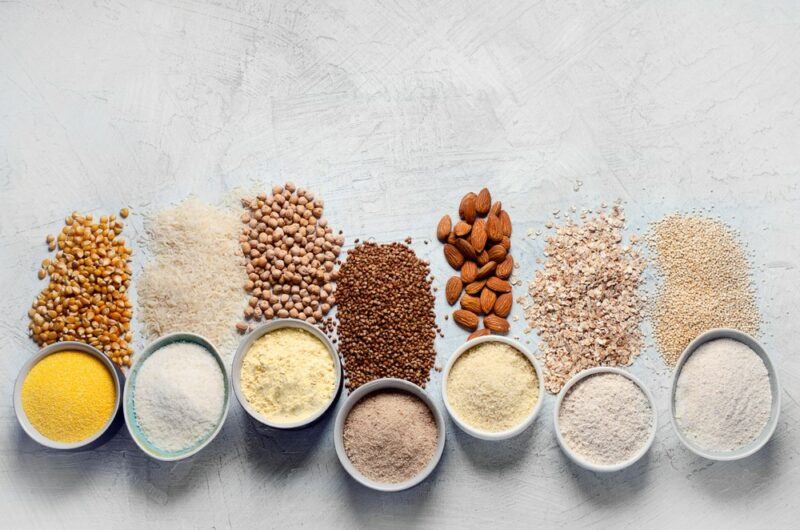 Small bowls of plant-based protein powder, with the main ingredient in the protein powder next to each one