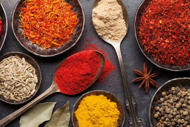 Various herbs and spices in dishes and on spoons