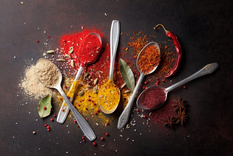 Small metal spoons with different spices