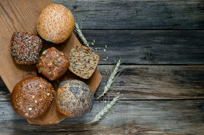 A wooden board with various bread rolls