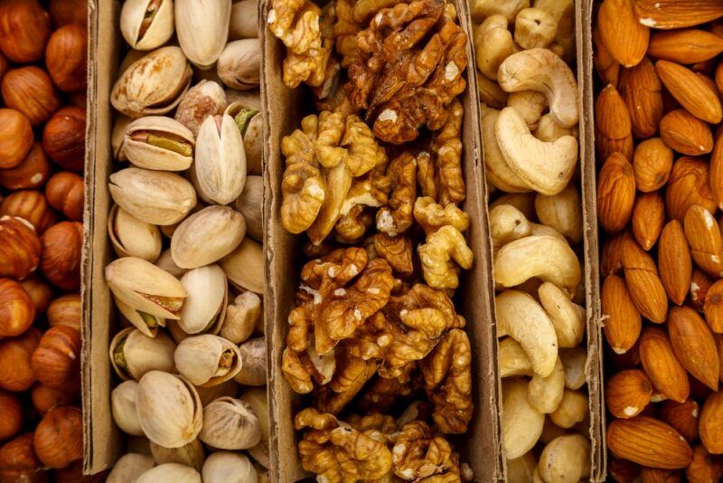 A tray with various wooden sections and different types of nuts