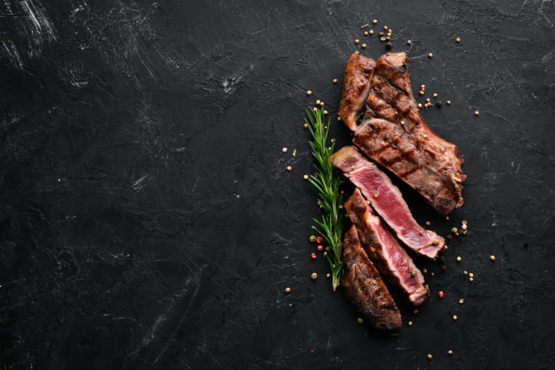 Cooked rare veal that has been sliced on a black background