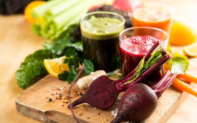 A glass of green juice and a glass of beet juice