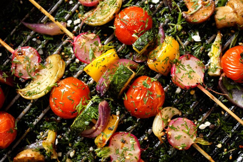 A selection of vegetables on skewers on a grill