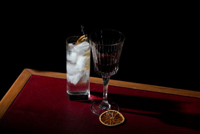 A cocktail with gin next to a glass of vermouth