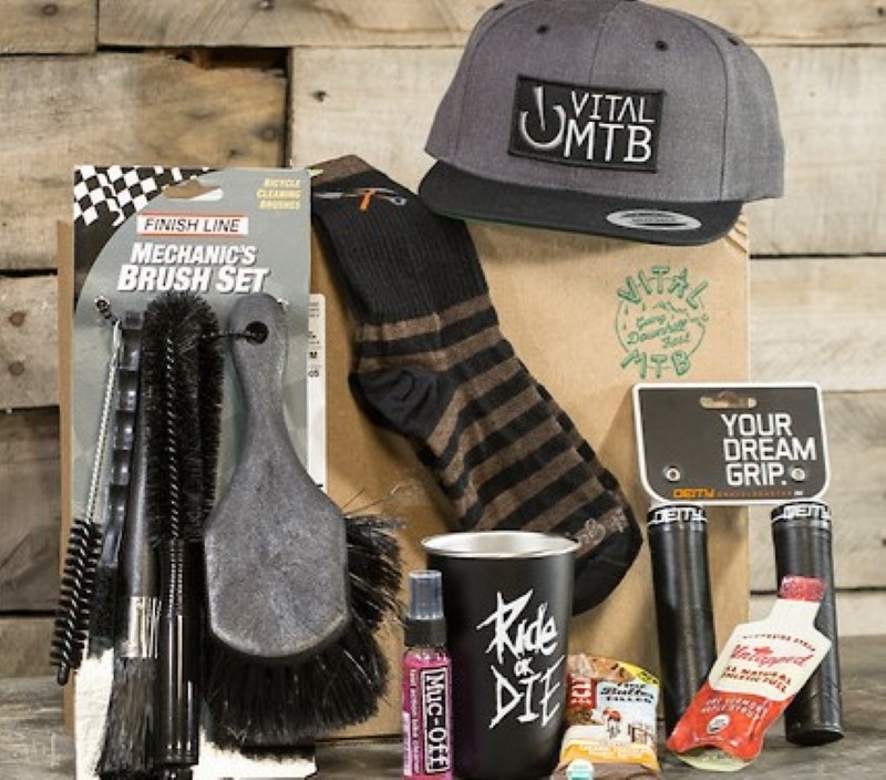 Vital MTB Gear Club box with various accessories including things like tumbler, mechanic brush set, hat, and socks