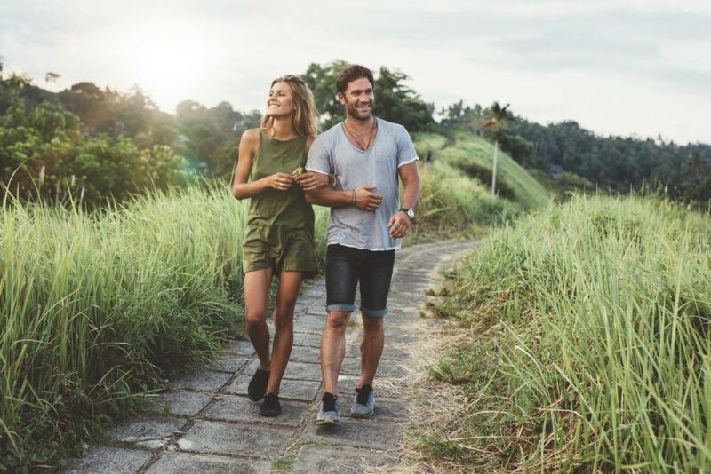 A couple walking towards the camera while they are outside