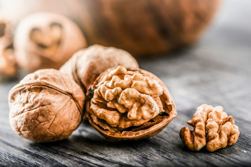 A handful of walnuts, one of which has been split open