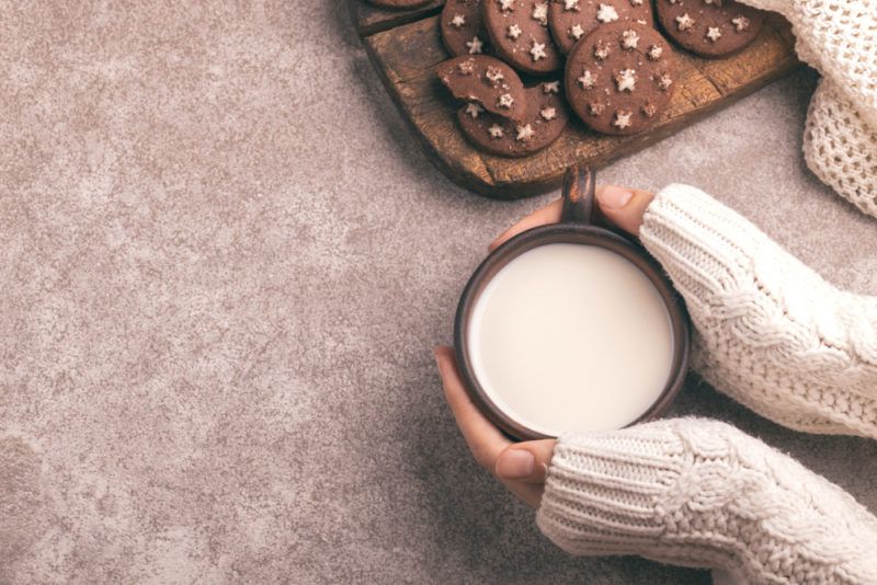 A mug of warm milk in a woman's hands