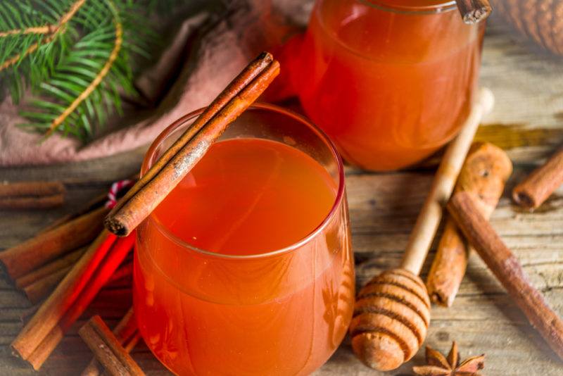 Two glasses of a Wassail cocktail, which is a type of mulled cider