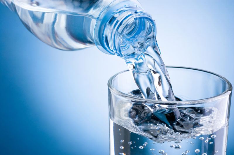 Water being poured from a bottle into a glass