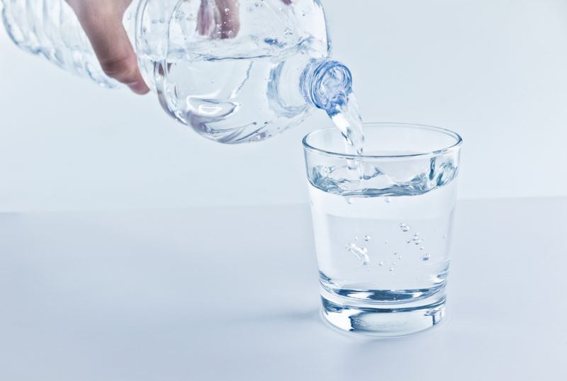 Water being poured from a bottle into a glass