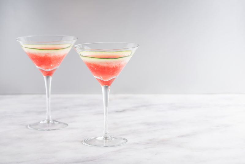 Two watermelon martinis on a marble table