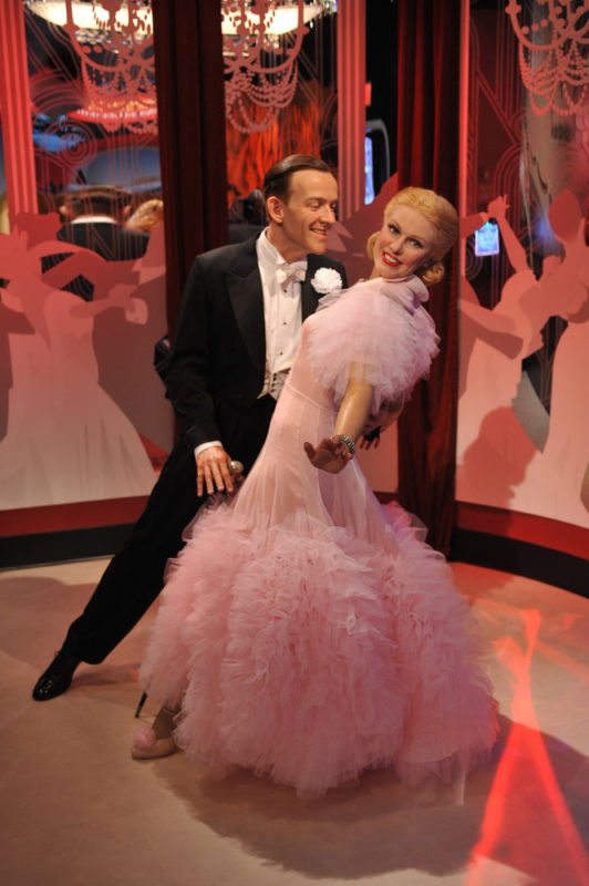 Wax figures of Ginger Rogers and Fred Astaire dancing, where Ginger Rogers is wearing a pink dress