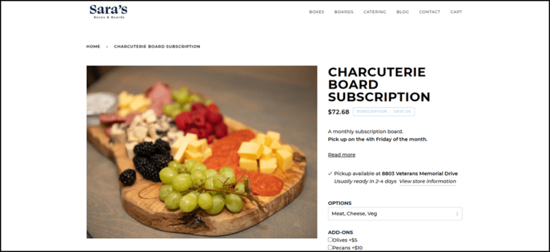 A wooden board with plenty of fruit, cheese, and meat from Sara's Boxes and Boards