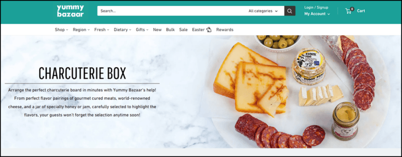 A website screenshot from Yummy Bazaar showing a board with plenty of meat, cheese, and olives