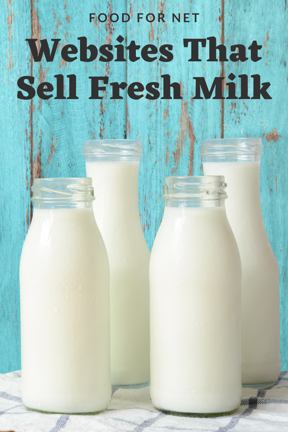 Four bottles of fresh milk against a light blue wooden wall on a tablecloth