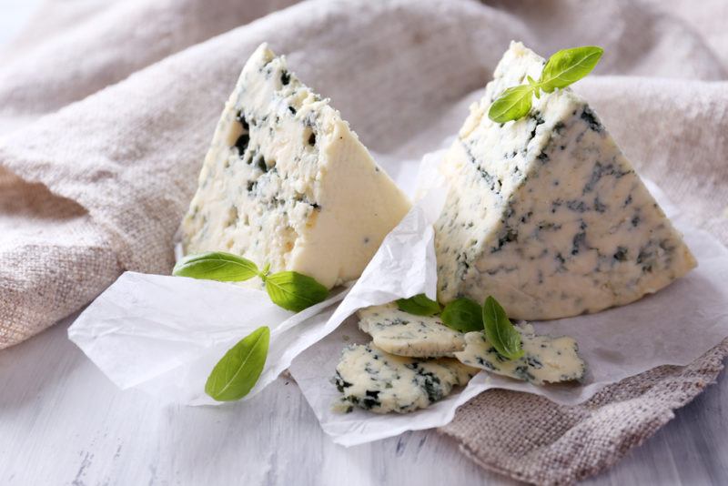 Wedges of blue cheese on paper and marble