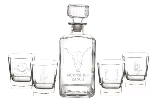 Western-Themed Decanter Set | Food For Net Four western-themed glasses and a whiskey decanter against a white background