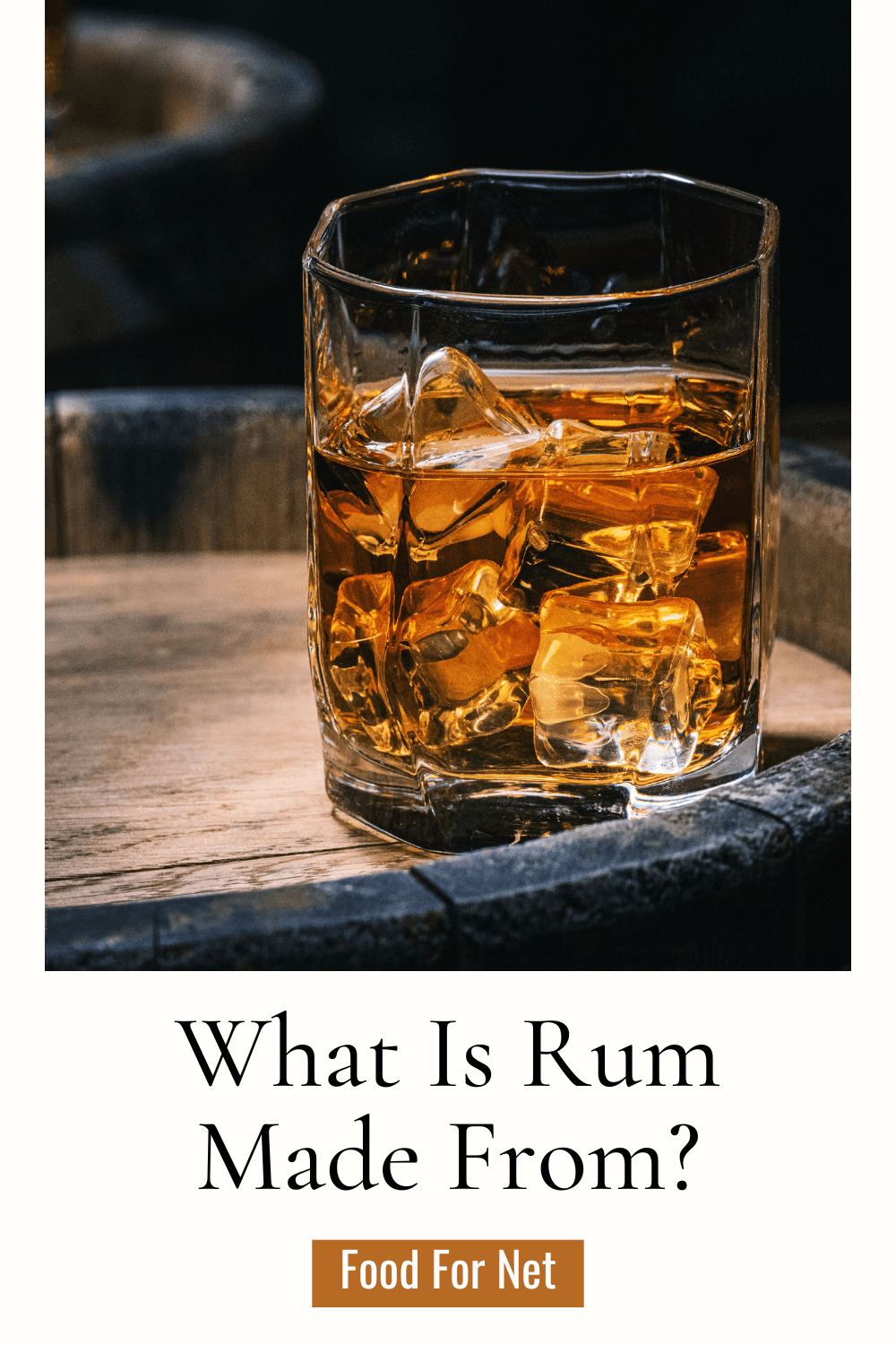 What Is Rum Made From? A glass of rum on top of a wooden barrel, highlighting the question of what is rum made from