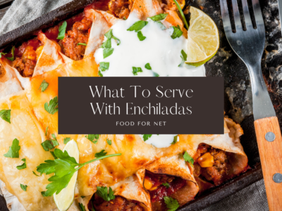 A large black dish of enchiladas topped with sour cream, next to a knife and fork, highlighting the question of what to serve with enchiladas