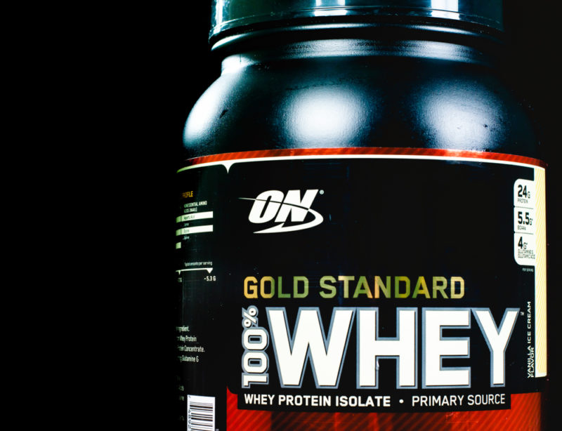 A black tub of Gold Standard Whey powder