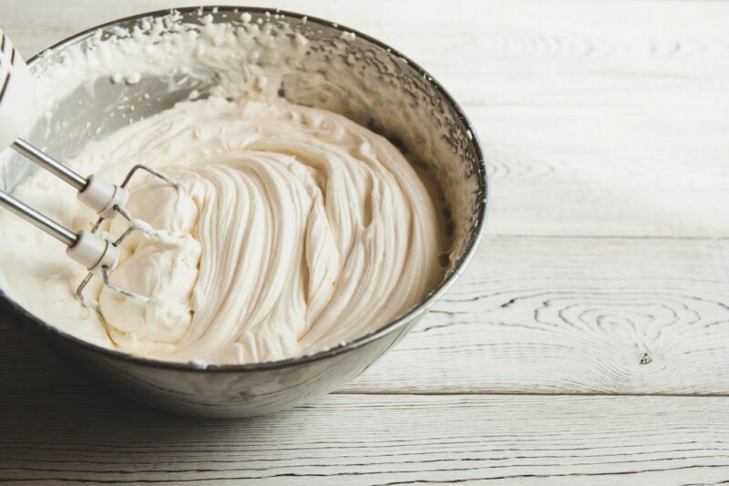 A bowl of cream cheese that has been whipped with sugar to be used for an air cheesecake