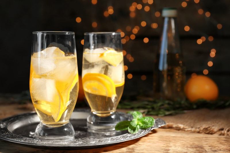 Two white wine spritzers against a dark background