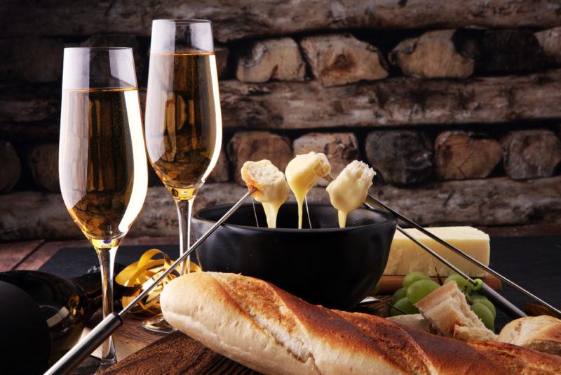 Two glasses of champagne next to a black fondue pot