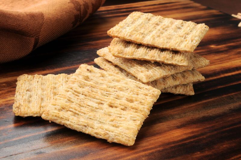 This photo shows several whole-wheat crackers resting on a wooden surface.