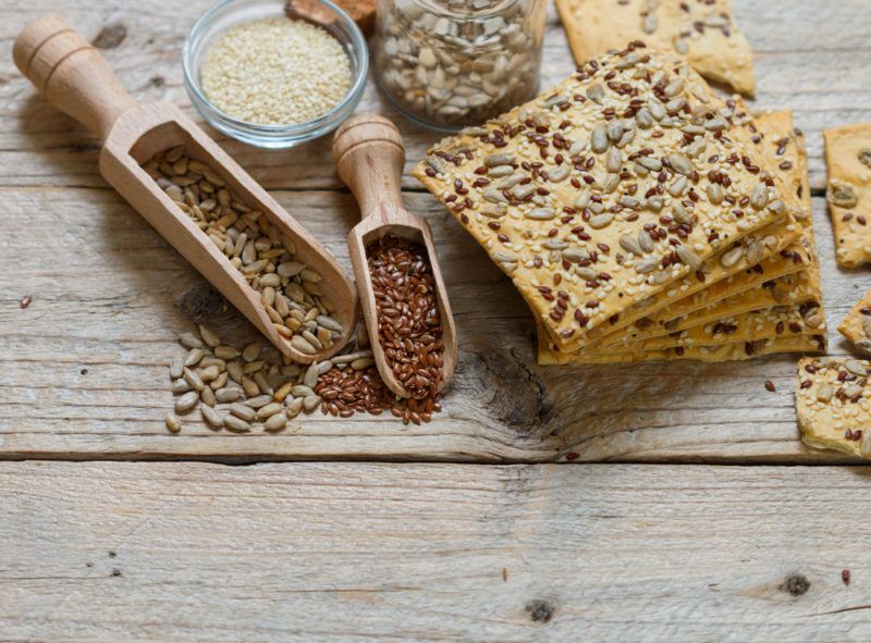 A selection of whole grain crackers and various seeds