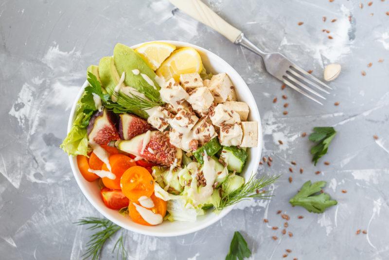 A white bowl with healthy ingredients and figs