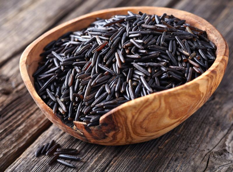 A wooden bowl with black wild rice