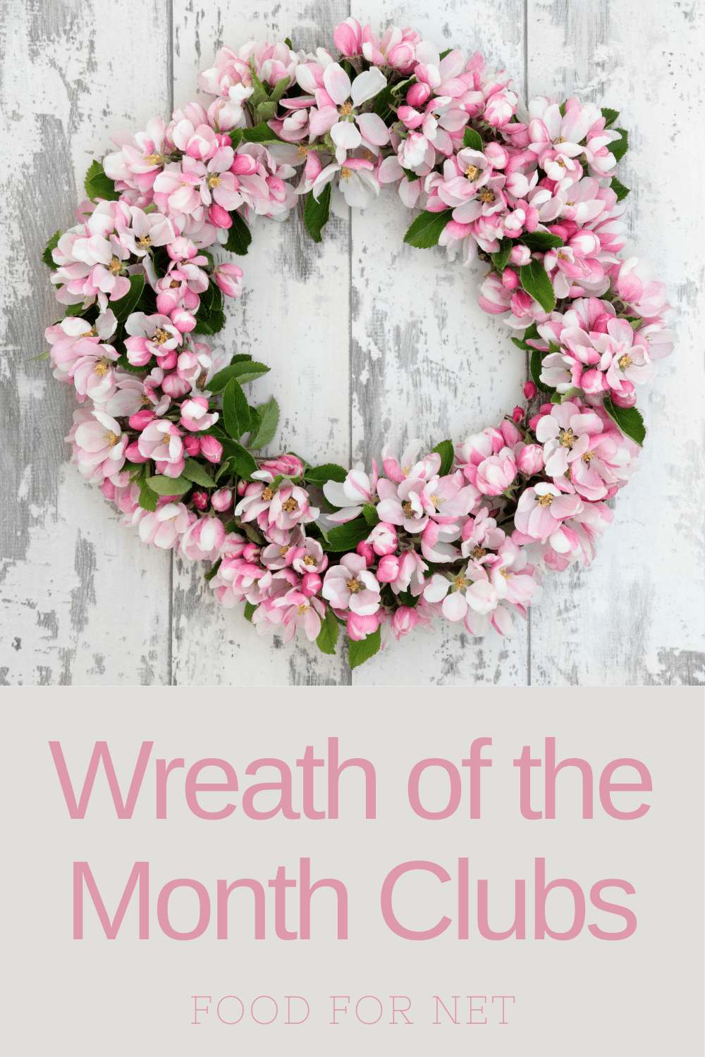 A pink and green wreath against a wooden white background