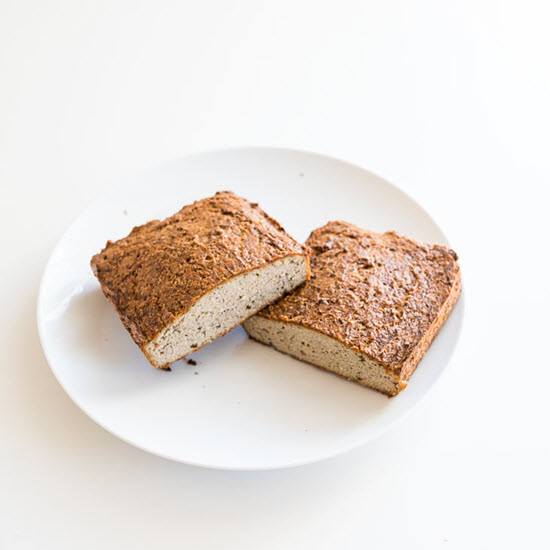 Two halves of a zucchini bread loaf on a white plate