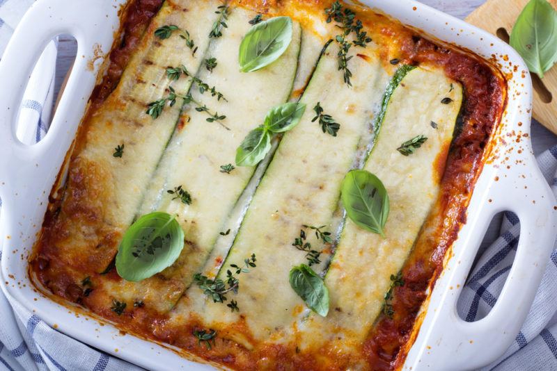 A lasagna in a white pan made using zucchini sheeds instead of pasta