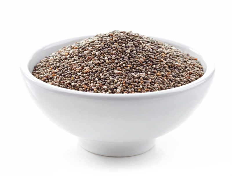 closeup shot of a white bowl filled with uncooked chia seeds