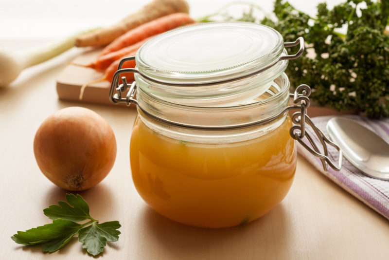 a jar of bone broth on a wooden table