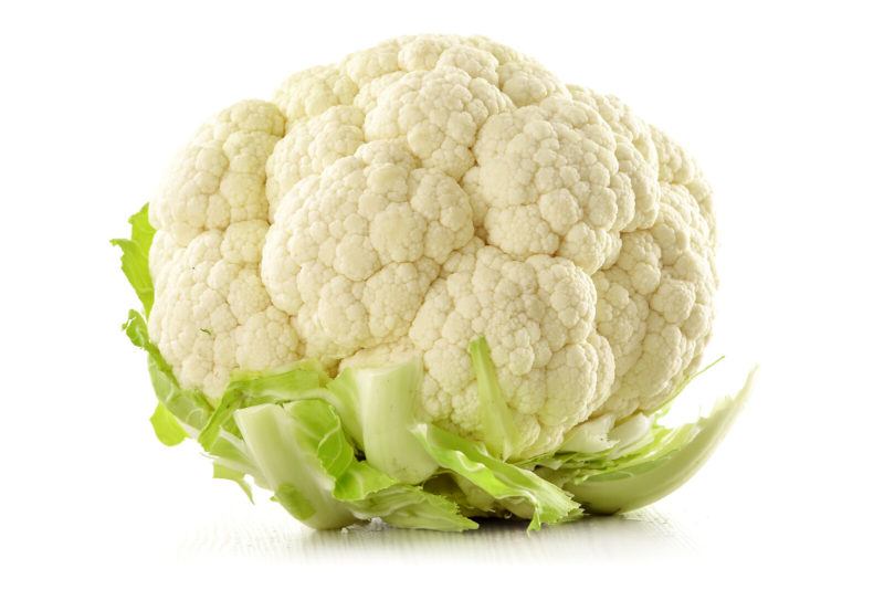 one whole head of cauliflower shot closeup with a white background